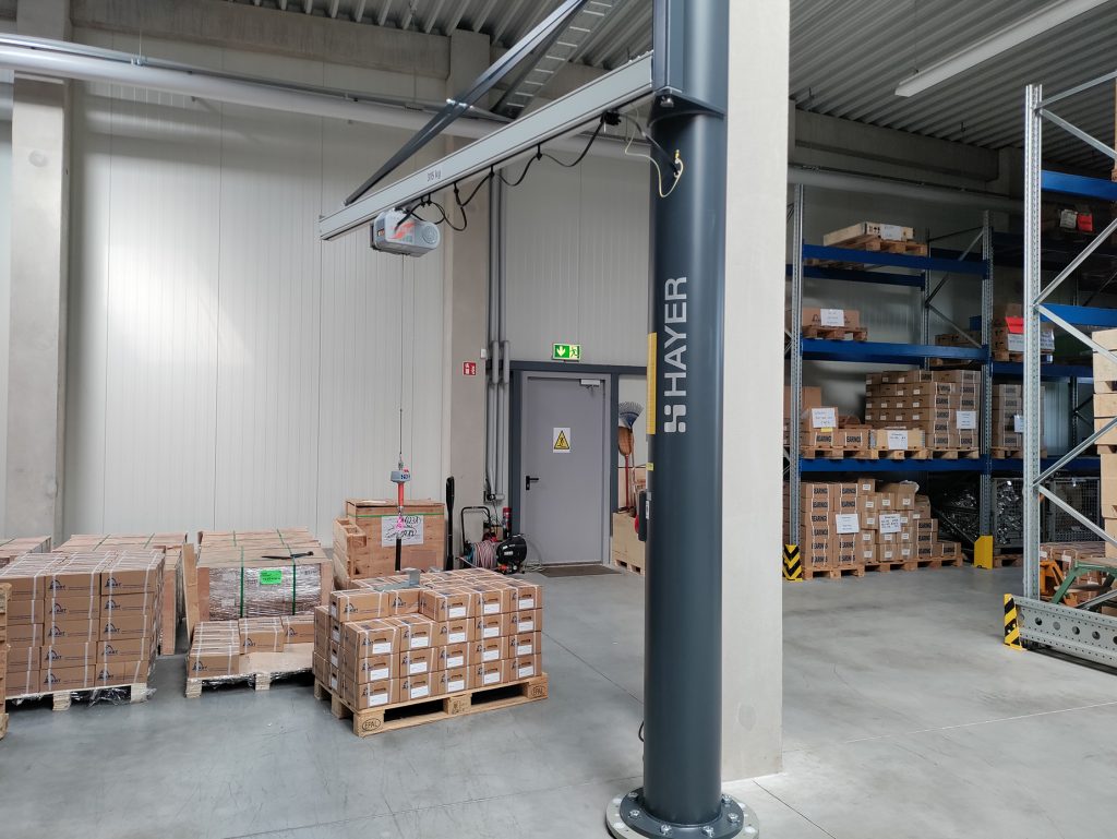 FastLift-Hebeanlage in einer Lagerhalle mit Paletten und Regalen.